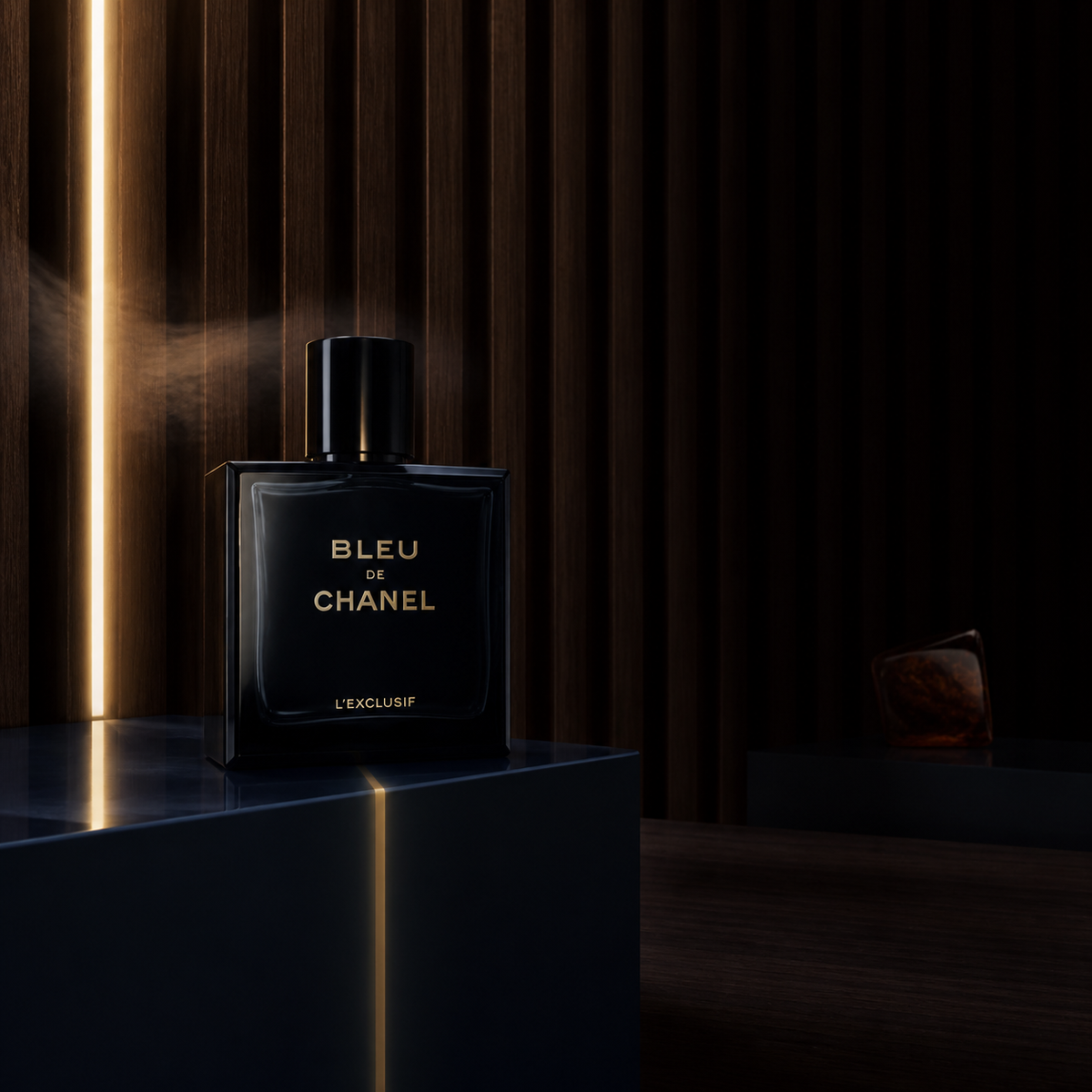 Chanel Bleu de Chanel L’Exclusif na tmavém podstavci před dřevěnou stěnou se svislým pruhem světla – MrRizz